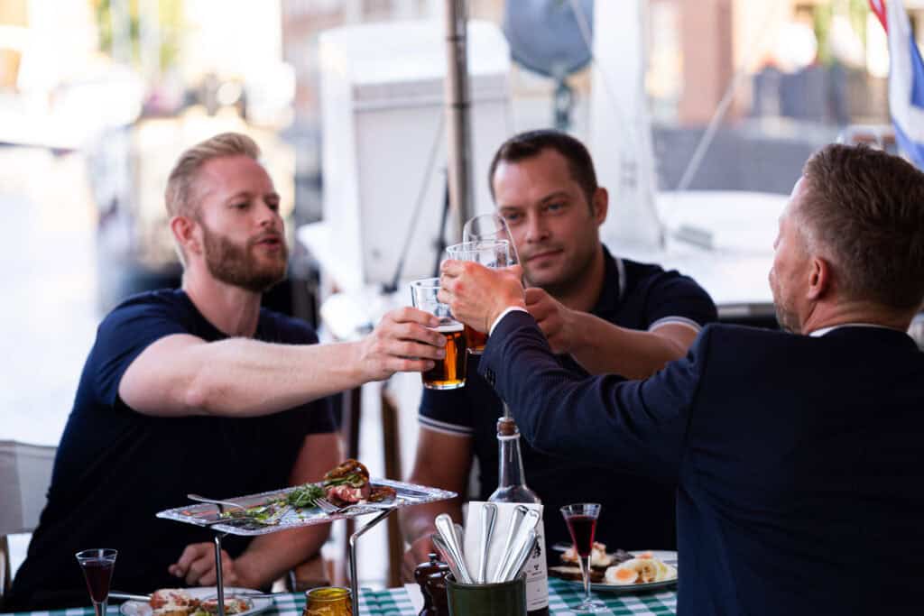3 herrer skåler i fadøl ved bord